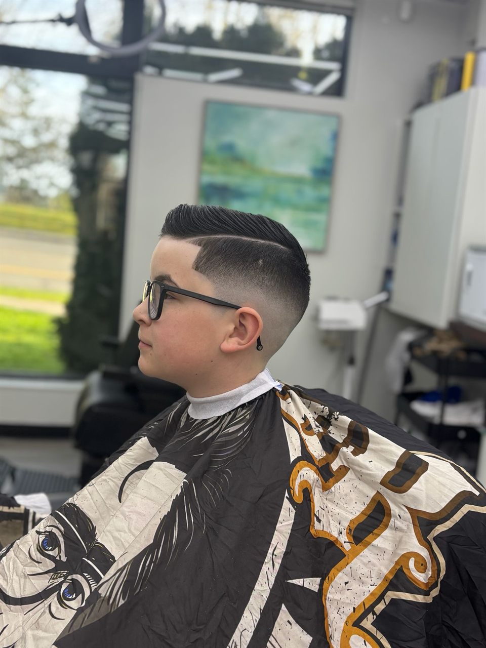 Young boy getting a fresh haircut at Royal Look Barber Shop near Royal Oak